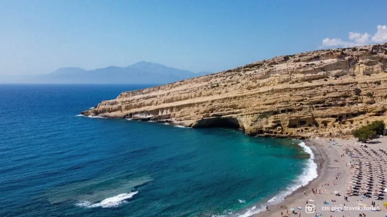 Drone shot of Matala Beach and Matala Caves on a clear day in Crete, Greece