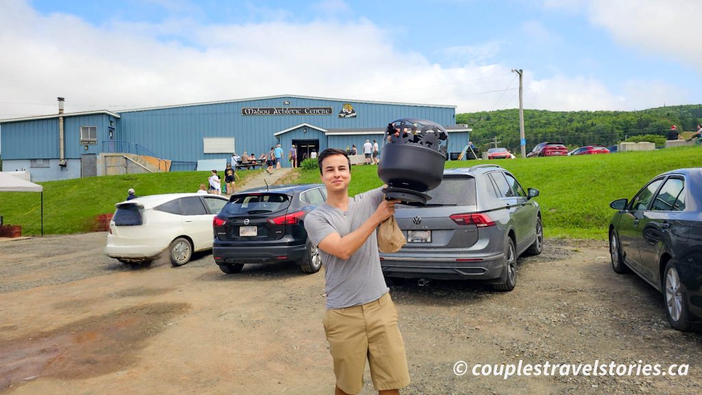Man carrying fire pit bought at mabou farmers market